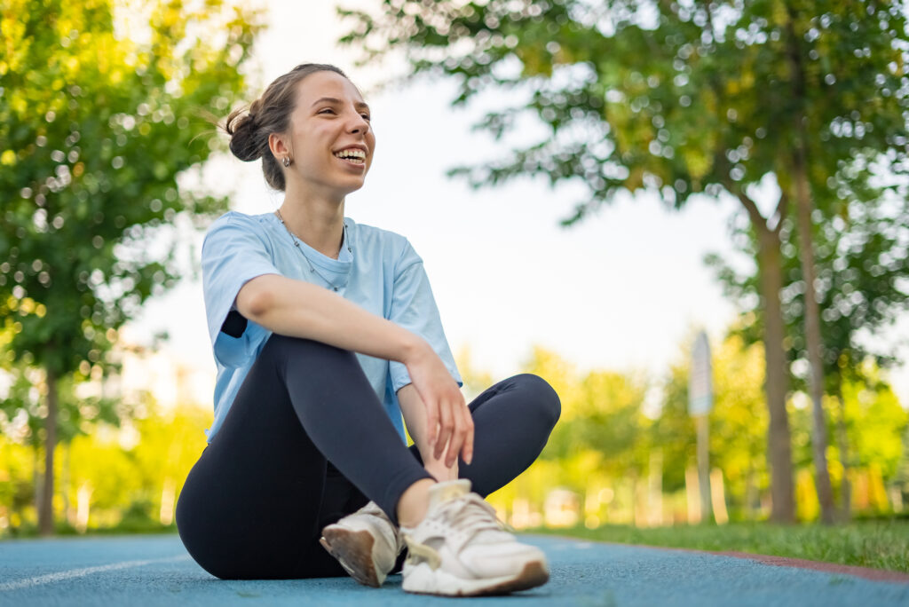 Young woman in the park relaxing and sitting on the grass